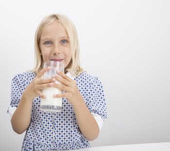 Portrait of little girl drinking milk