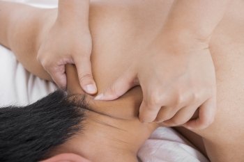 Cropped image of woman massaging man’s shoulder in bed