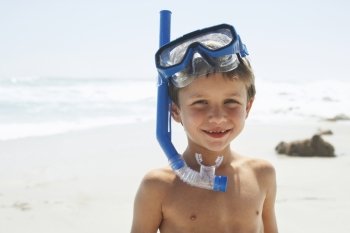 Portrait of cute little boy wearing snorkel while standing on beach