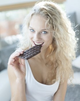 Portrait of sensuous woman eating candy bar