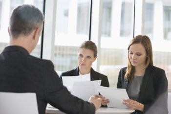 Business people discussing paperwork in office cafeteria