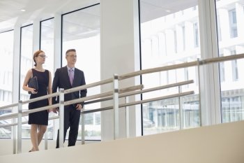 Business people walking by railing in office