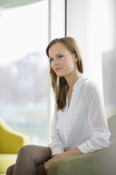 Thoughtful young businesswoman in office lobby