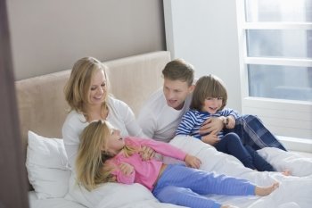 Parents playing with children in bedroom