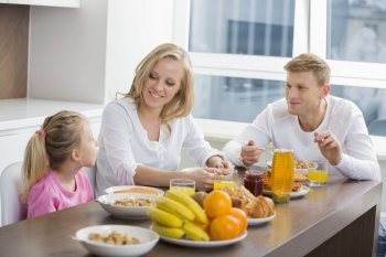 Happy family of three having breakfast at table