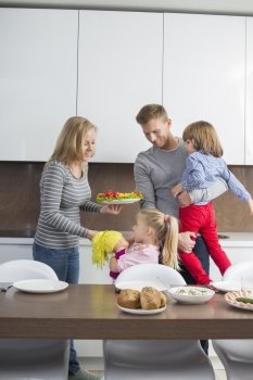 Happy family with children having meal in domestic kitchen