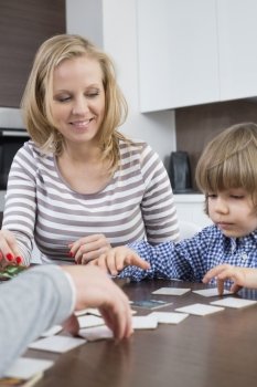 Boy playing cards with parents at home