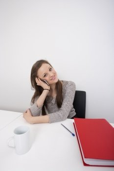 Portrait of beautiful businesswoman using cell phone at office desk