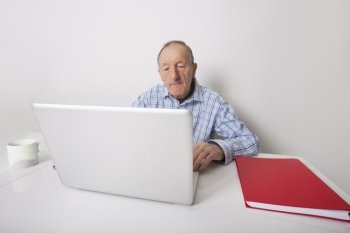 Senior businessman using laptop at office desk