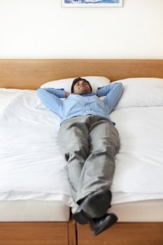 Full length of young businessman sleeping in hotel room