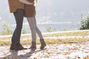Low section of couple standing in park during autumn