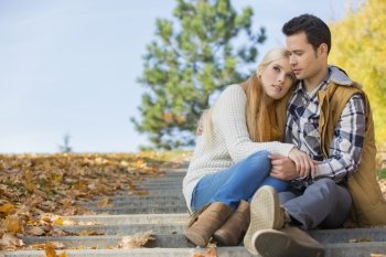 Loving couple sitting on park steps