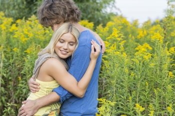 Side view of affectionate couple hugging in field