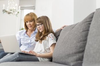 Mother and daughter using laptop together at home
