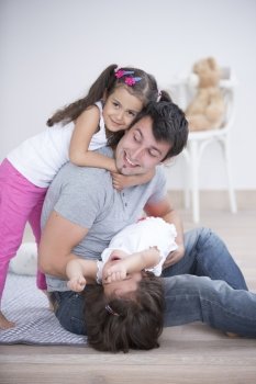 Father with playful daughters at home