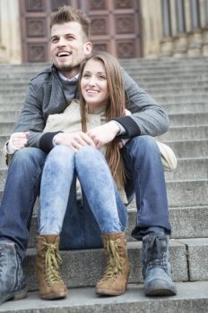 Full length of young couple sitting on steps outdoors