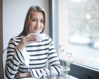 Portrait of smiling woman having coffee at cafe table
