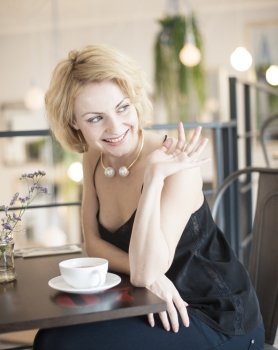 Happy young woman waving at restaurant table