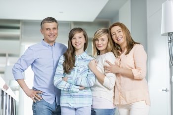 Portrait of happy family with children standing together at home