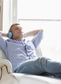 Relaxed Middle-aged man listening to music at home
