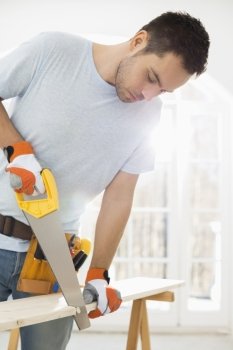 Man sawing wood in new house