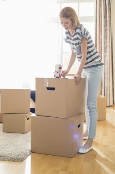 Woman packing cardboard box at home