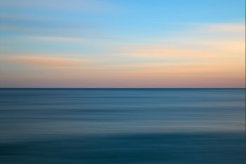 Beautiful long exposure seascape image of calm ocean at sunset