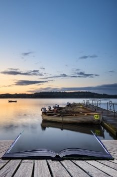 Landscape sunrise over still lake with boats on jetty conceptual book image