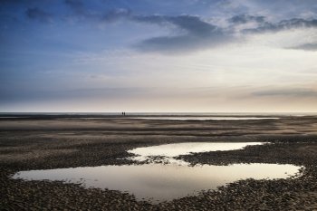 Conceptual landscape image of two people on remote beach