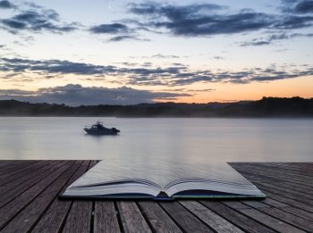 Sunrise landscape of boat on calm lake conceptual book image