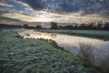 Countryside sunrise landscape with dramatic sky and flowing river