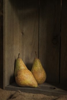 Pears in rustic setting with wooden box and hessian sack with added texture filter