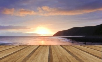 sunrise over incoming tide with rocky foreground and cliffs with wooden planks floor