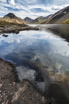 Stunning landscape of Wast Water and Lake District Peaks on Summer day reflected in perfect lake