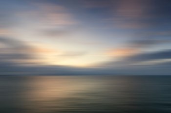 Beautiful colorful sunrise landscape over calm sea with blur effect added