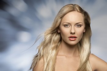 attractive blonde woman in close-up portrait posing with long flying silky hair and perfect skin. Looking in camera 