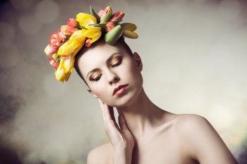 spring shoot of sexy young lady with naked shoulders, floral garland on her head and colorful make-up