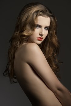 sexy girl with long wavy hair, naked shoulders and cool make-up. Charming portrait