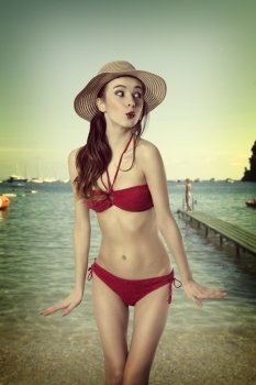 very sexy nice girl in red bikini in funny pose with a simmer hat . old fashion color. Summer time