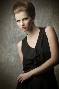 charming female posing in fashion portrait with elegant creative hair-style, stylish make-up and black dress