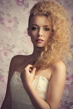 beautiful young blonde lady posing in close-up fashion shoot with creative stylish hair-style, colorful make-up and elegant white dress
