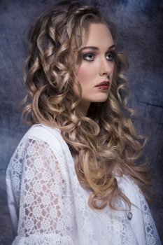 pretty curly blonde woman with stylish make-up posing in fashion portrait with vintage elegant clothes. 