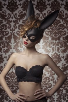 sexy woman with lace stylish lingerie posing with bizarre bunny mask in glamour portrait. Dark Easter 