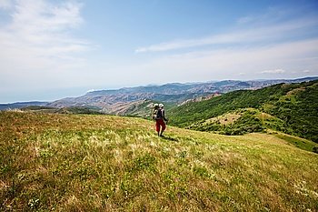 Backpacker in summer mountains