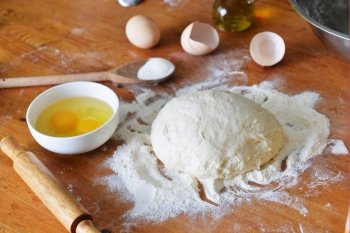 yeast dough, eggs  and flour on wooden background