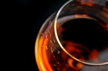  snifter of  brandy in  elegant  glass.  black background