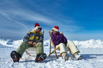 Couple at mountains in Santa hats celebrating christmas, Meribel, Alps, France