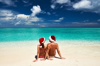 Couple in santa’s hat on a tropical beach at Maldives