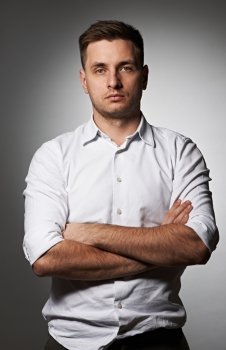 Portrait of serious man in shirt against grey background