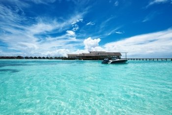 Beautiful island beach with motor boat at Maldives
